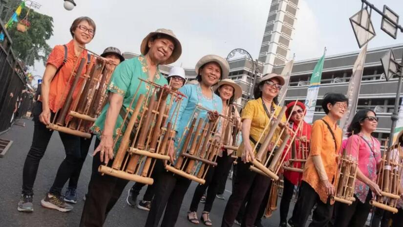 Portando instrumentos musicales tradicionales indonesios, varias personas participan en un desfile en el marco del «Día sin coches» en la ciudad de Surabaya, Indonesia. La Cruz Roja Indonesia participó en el evento para concienciar sobre los peligros de las olas de calor.