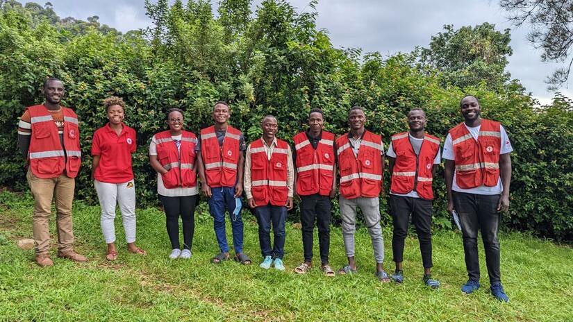 Dr Joseph Kasumba stands with trained safe and dignified burials volunteers from the Uganda Red Cross.