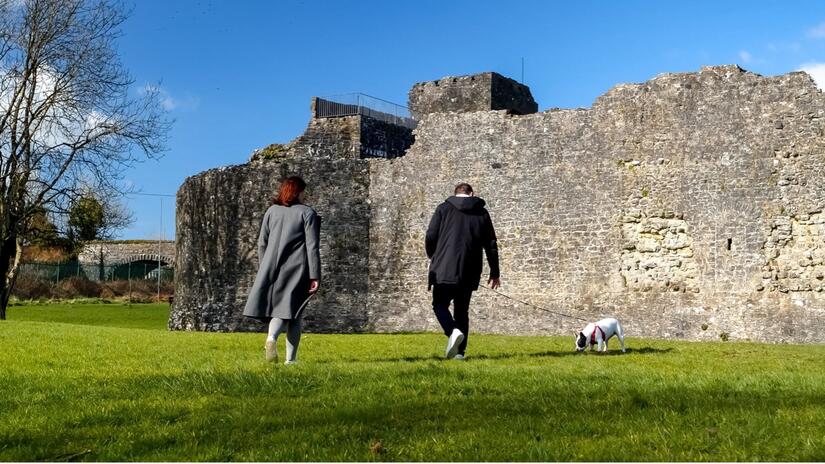 دميترو كيكفيدز وأناستاسيا هونشاروفا يسيران مع كلبهما في سليغو، أيرلندا، حيث تستضيف عائلة أيرلندية الزوجين منذ أكثر من عام. 