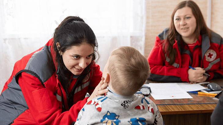 الدكتورة يرينا موشينسكا من الوحدة الصحية المتنقلة التابعة للصليب الأحمر الأوكراني تقوم بفحص ياروسلاف، البالغ من العمر 4 سنوات، في كورماني، مقاطعة سومي، أوكرانيا. تضمن الفحوصات المنتظمة سلامة الأطفال المتأثرين بالنزاع. 